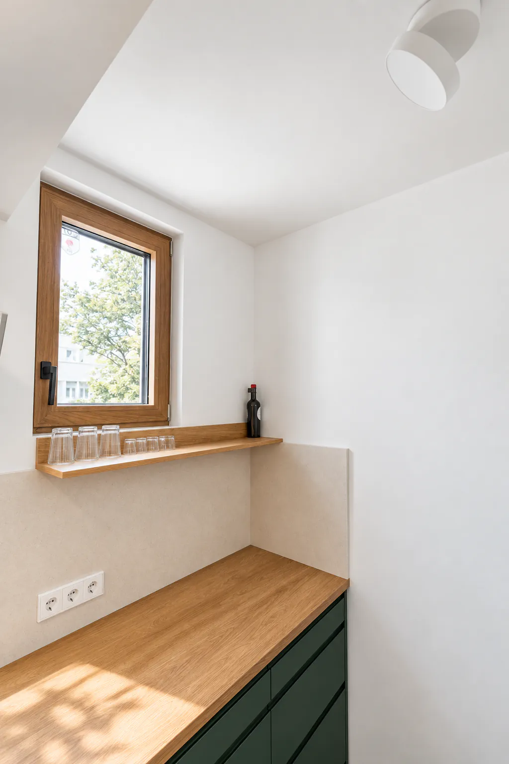 Дървен плот и рафт под прозореца в кухненския кът